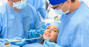 Patient undergoing restorative dentistry surgery with a team in blue surgical attire.
